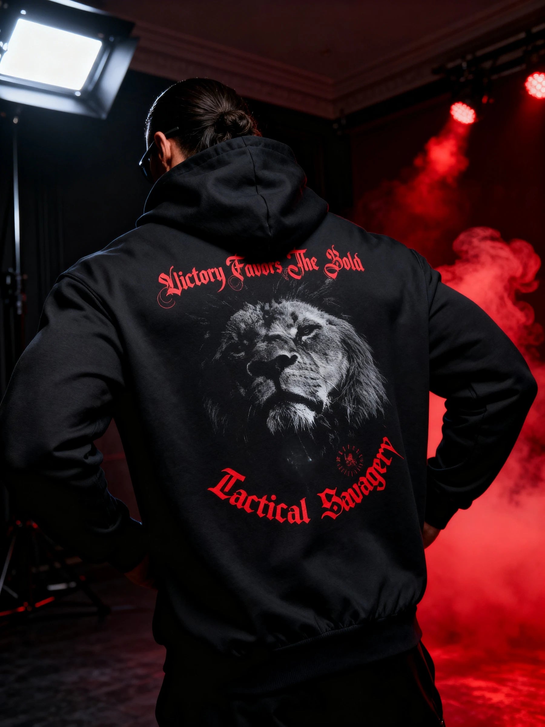Men's lion graphic gym hoodie – model in Victory Favors The Bold hoodie, red smoke studio lifestyle shot. Warface Athletics.