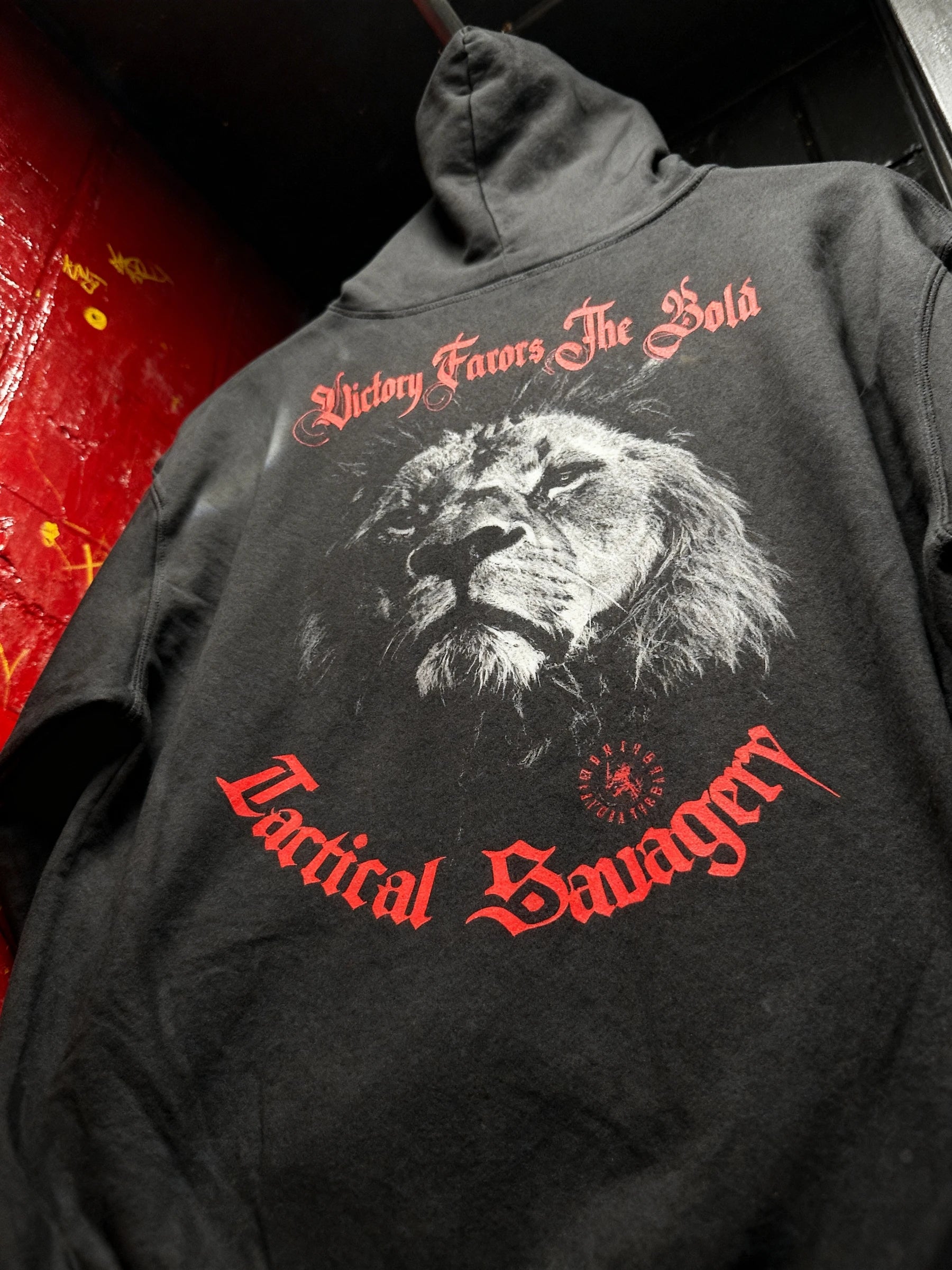 Victory Favors The Bold lion gym hoodie front – men's black graphic hoodie, Tactical Savagery red gothic text. Warface Athletics.