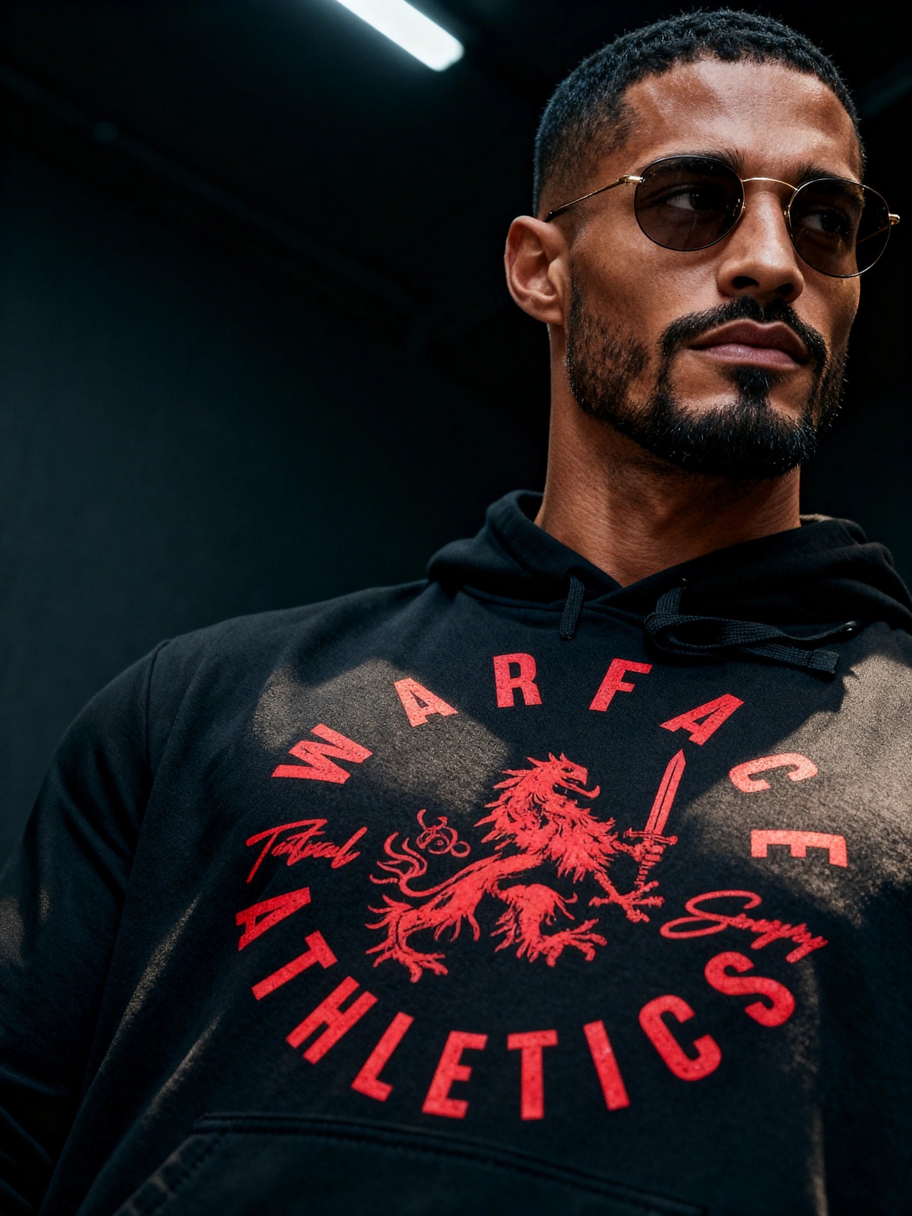 Men's Warface Athletics graphic hoodie – model in Tactical Savagery heraldic lion pump cover, dark background lifestyle.