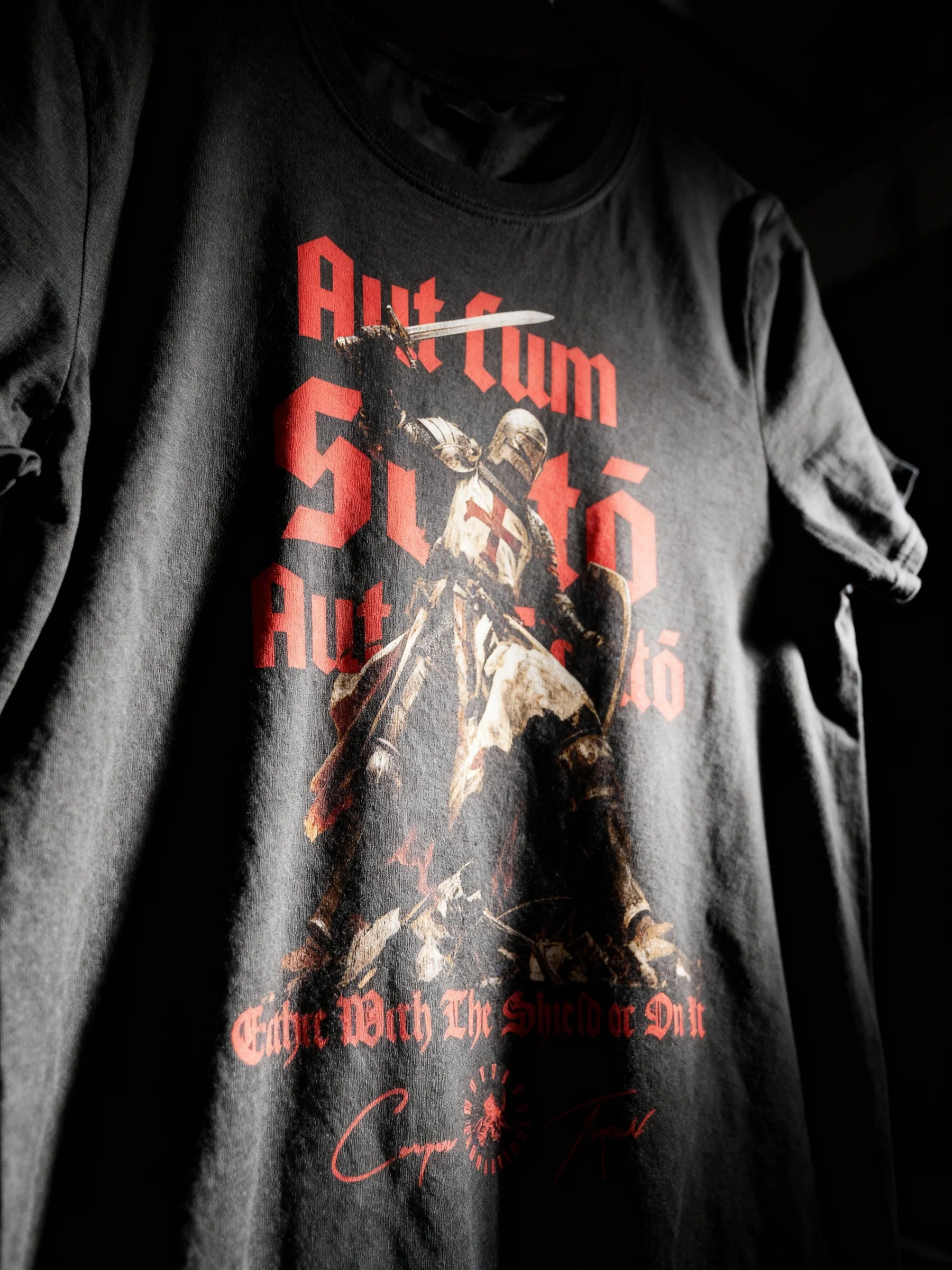 Aut Cum Scuto Aut In Scuto flat lay – men's black Templar knight heavyweight gym shirt, Comfort Colors 1717.