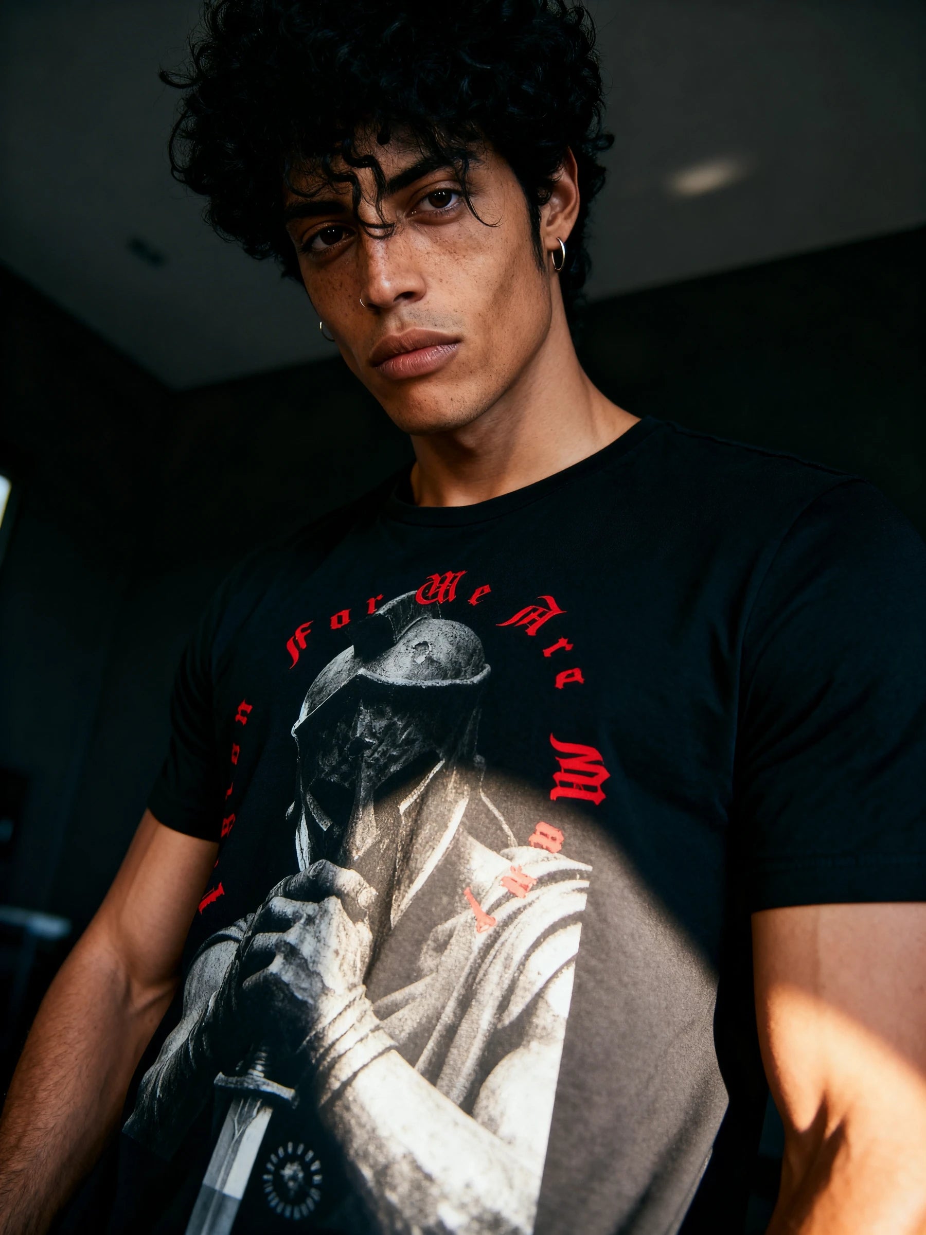 Men's Legion For We Are Many gym shirt – model in athleisure spartan graphic tee in dark room. Warface Athletics.