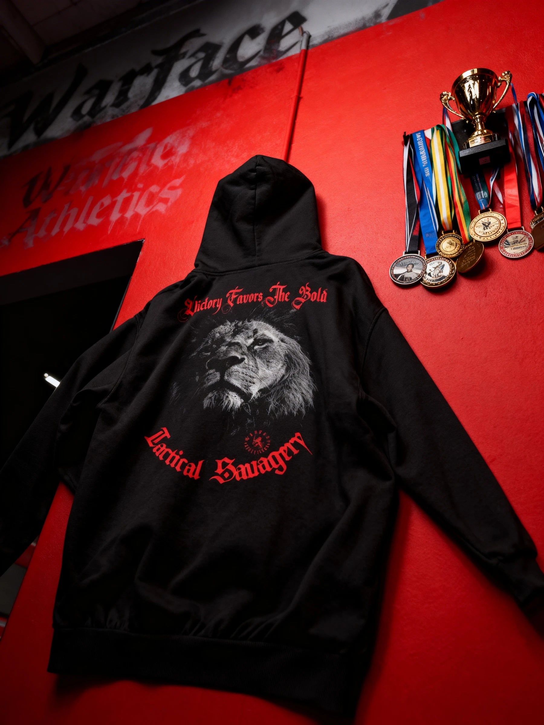 Victory Favors The Bold lion gym hoodie – men's black graphic hoodie on red background with trophies, pump cover. Warface Athletics.