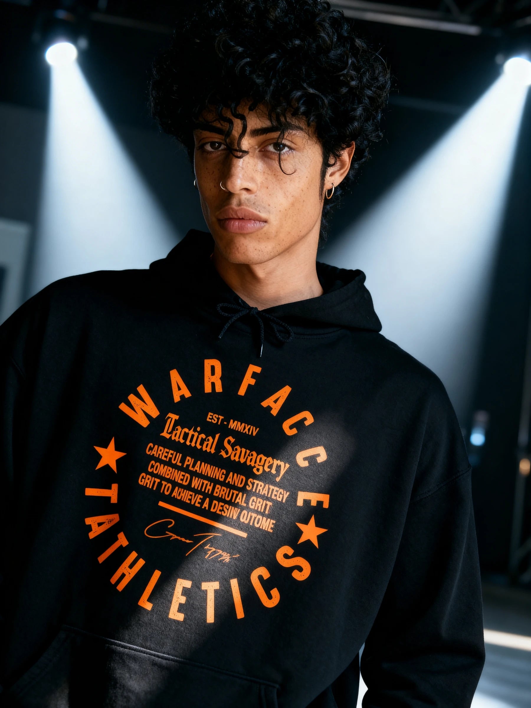 Men's Julius Caesar gym hoodie – streetwear model in Veni Vidi Vici black hoodie, darkly lit setting. Warface Athletics.
