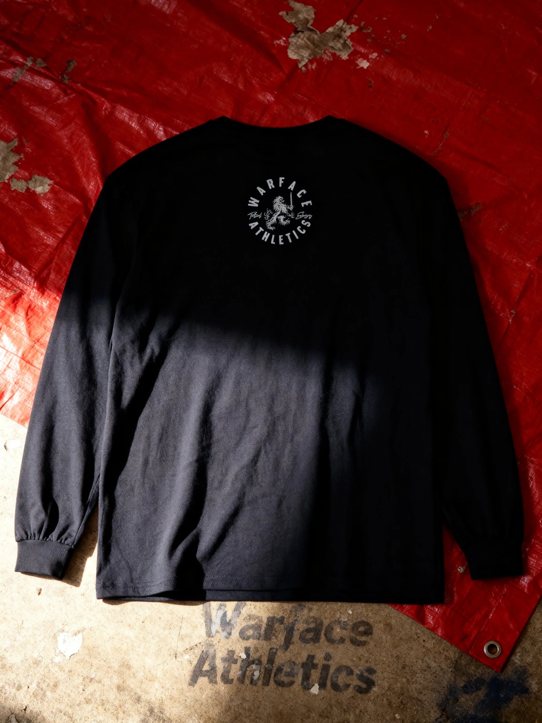 Black long-sleeve shirt with 'Warface Athletics' logo on a red and beige textured background