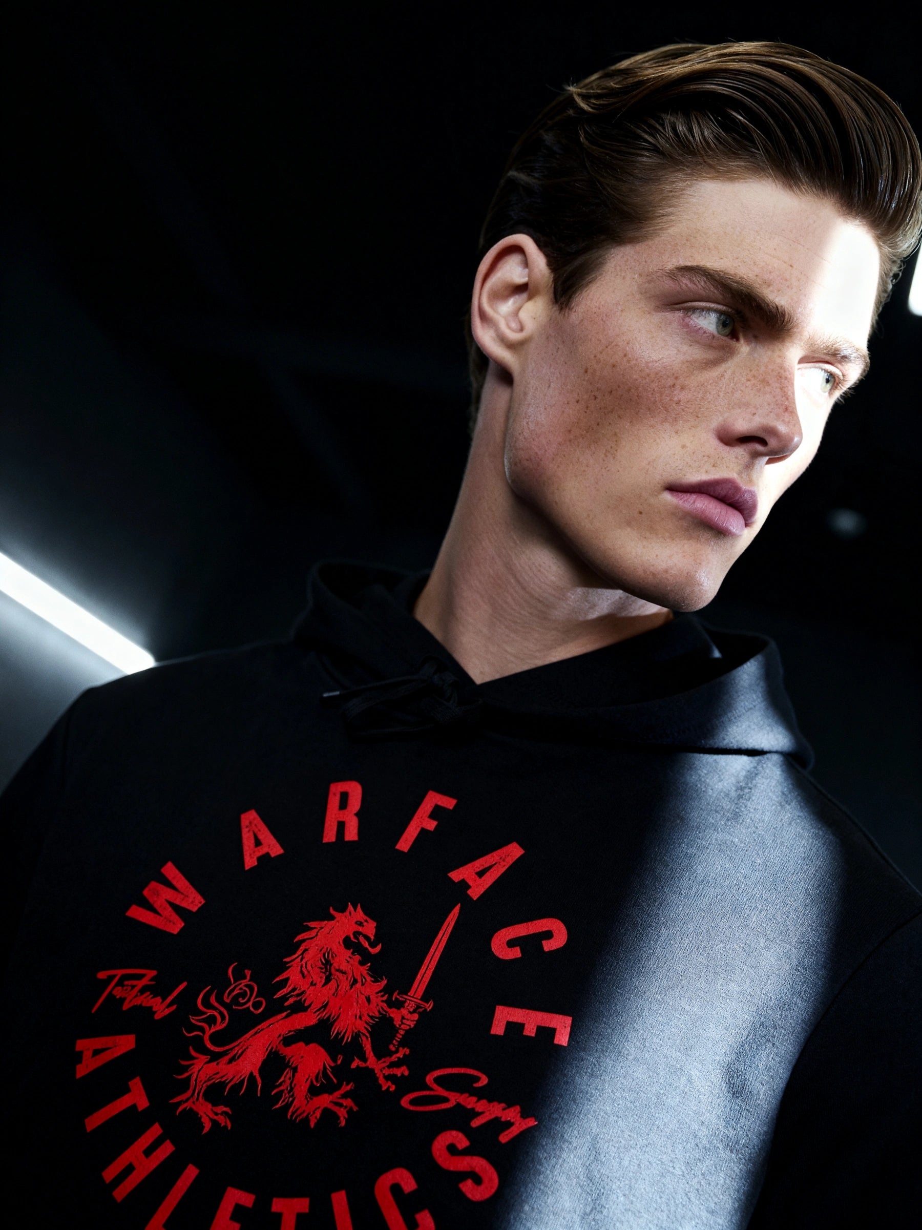 Men's heraldic lion gym hoodie – streetwear model wearing Tactical Savagery graphic hoodie, dark background. Warface Athletics.